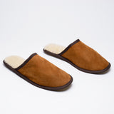 Pair of tan lambskin slippers with cream wool lining, on a white background