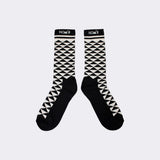 Pair of NOM*d socks with a black and cream triangle pattern and black heels and toes