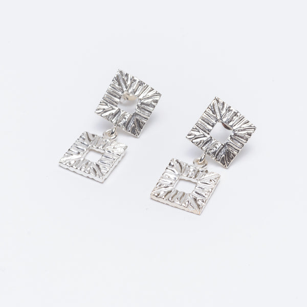 Silver earrings with two square components.