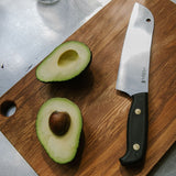 Santoku chef's knife on rimu chopping board with avocado. 